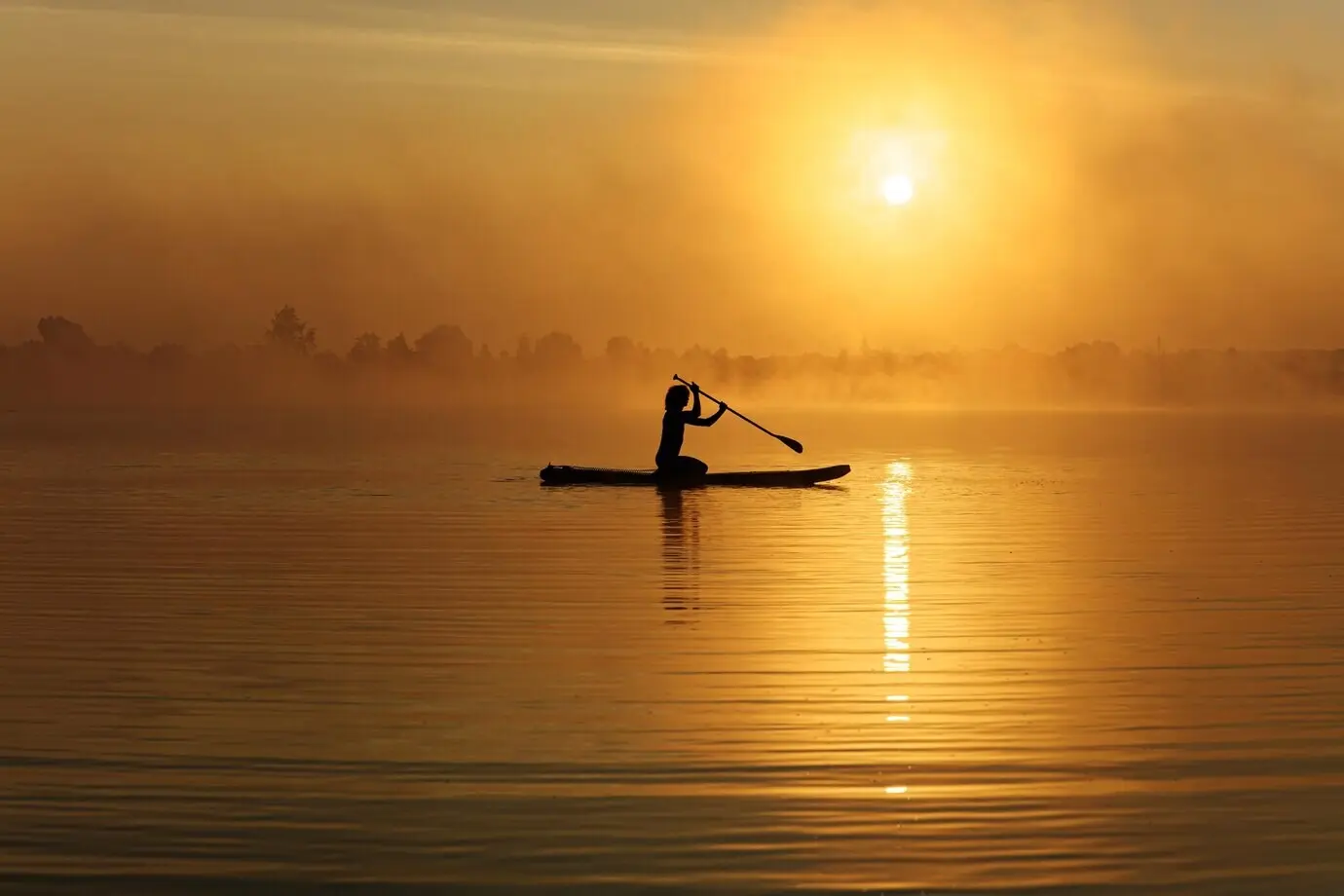 A silhouetted sportsman wandering on board during sunrise