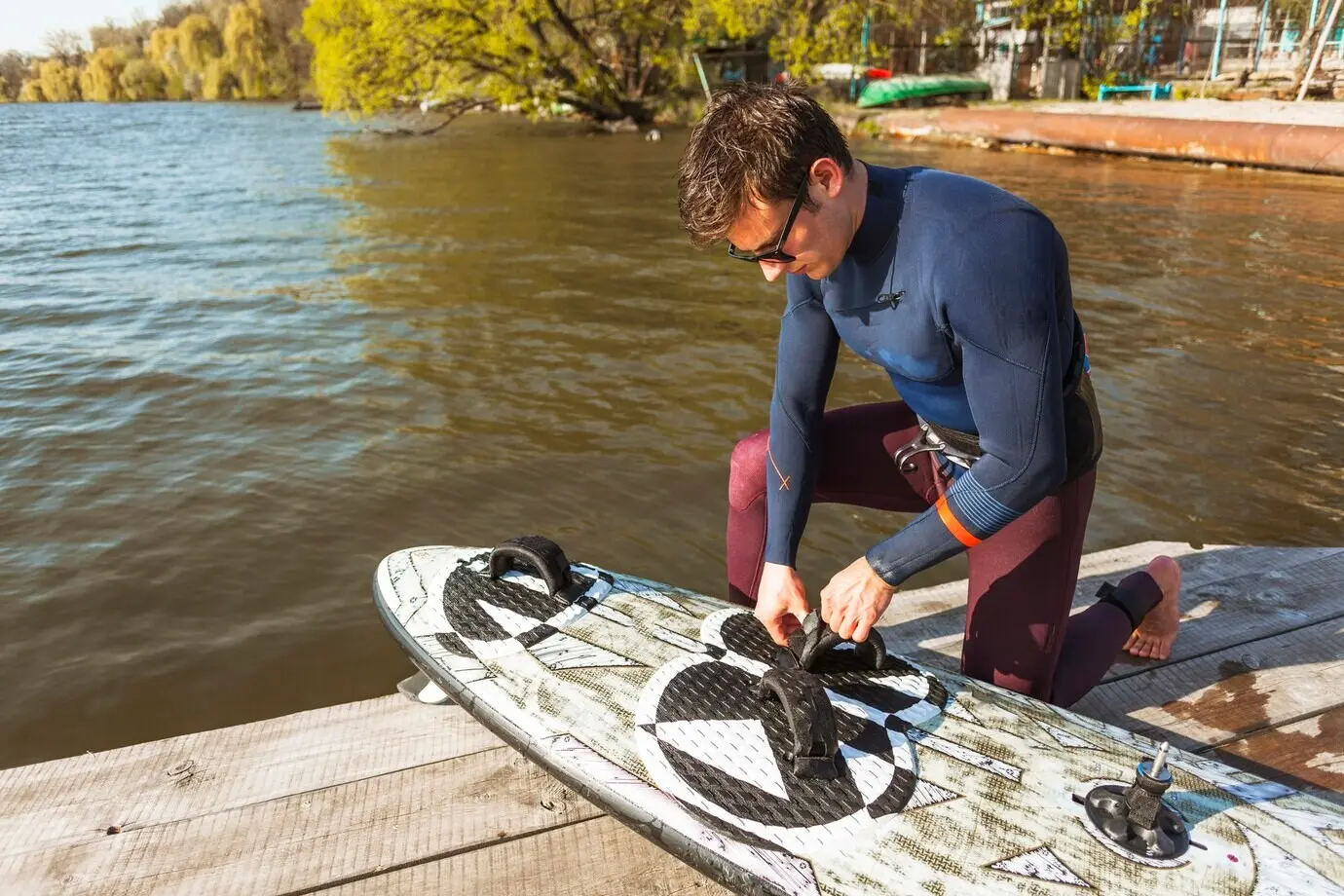 A young man with a kitesurf board