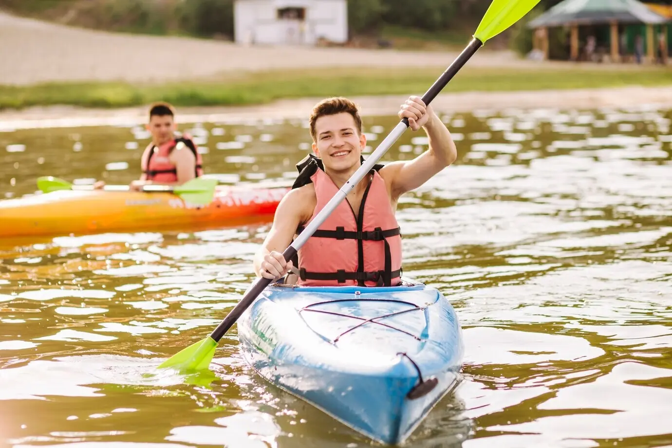 A male enjoying kayaking on a lake.