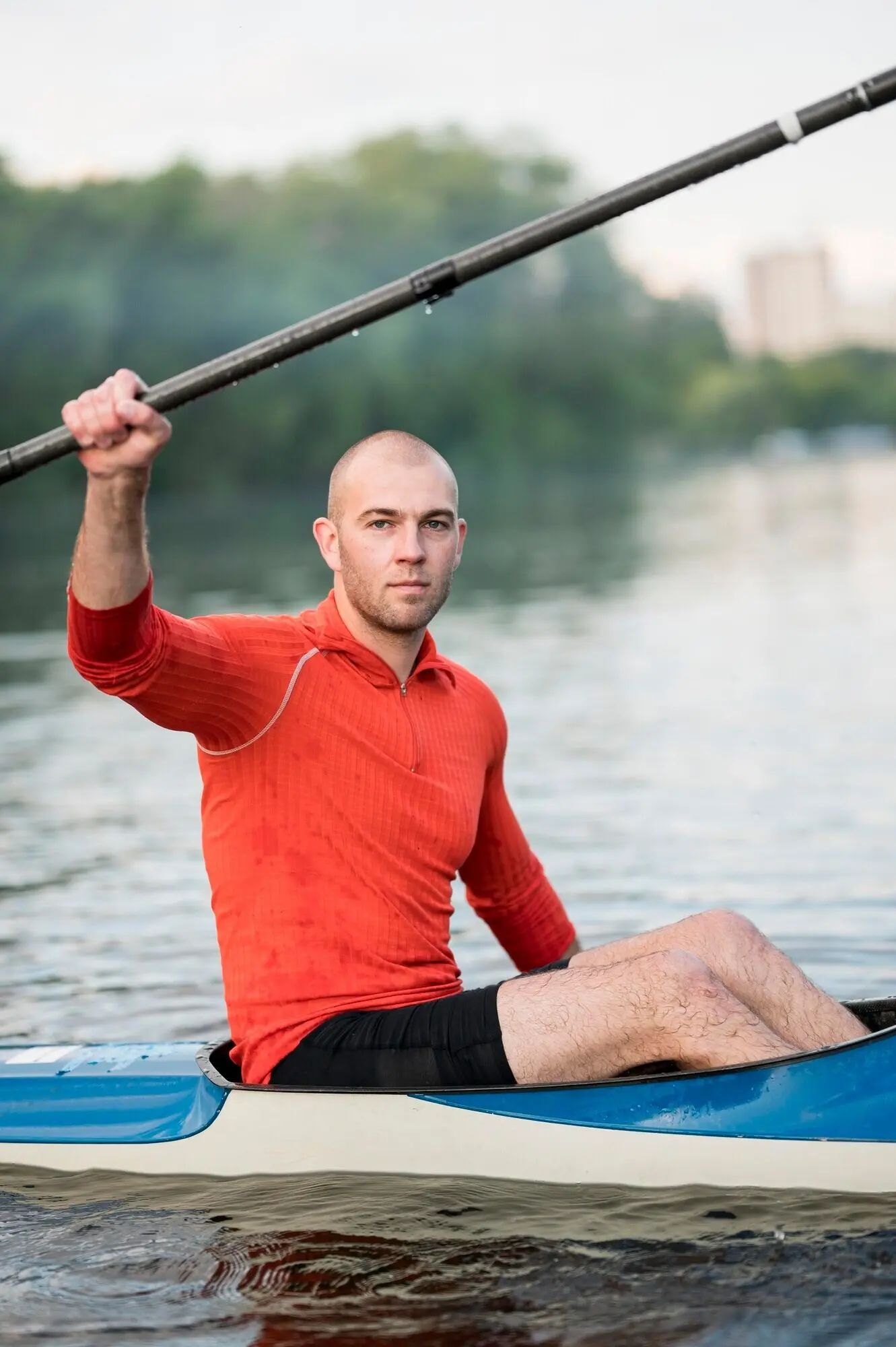 Side view of a man in a kayak with an oar.